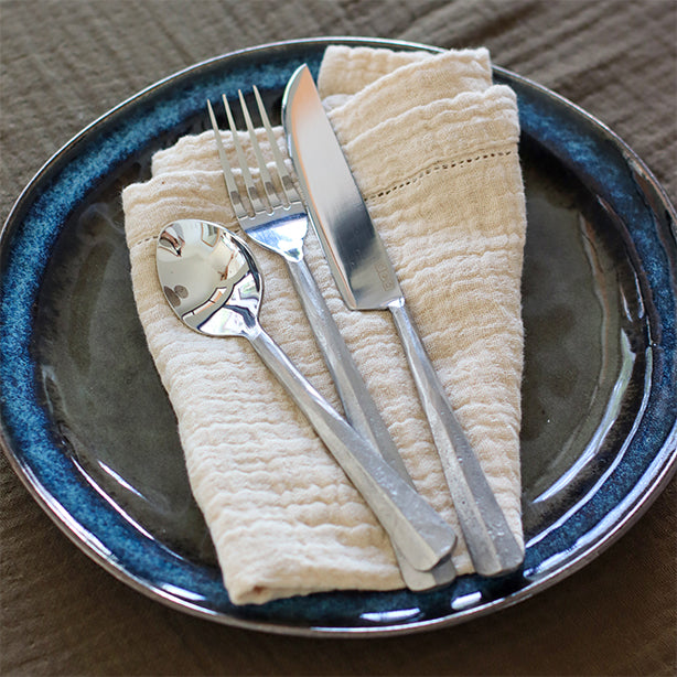 Assiette CERTALDO dressée avec une serviette ORIGIN et les couverts AITO